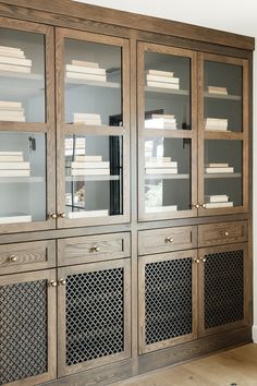 a wooden bookcase with glass doors and metal inserts