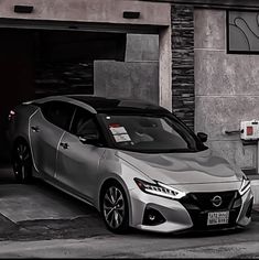 a silver sports car parked in front of a building