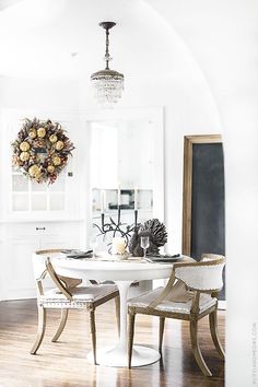 a dining room table with two chairs and a chandelier