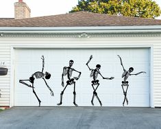 three skeletons dancing in front of a garage with the door open to reveal a driveway