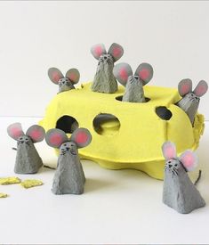 some paper mice are standing in front of a piece of yellow and gray material with red eyes