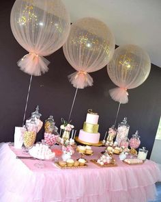 a table topped with lots of cake and balloons