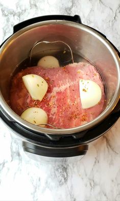 the meat is being cooked in the slow cooker with potatoes and seasonings on top