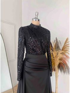 a black dress with sequins on it and a mannequin in the background