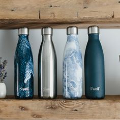 thermos and bottles are lined up on a shelf