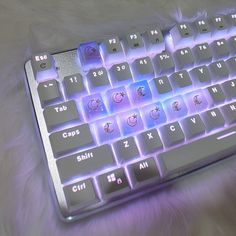 a close up of a computer keyboard on a furry surface with blue light coming from the keys