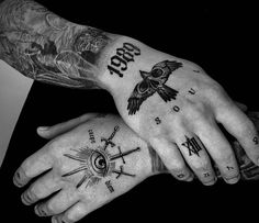 two people with tattoos on their arms holding each other's hands and looking at the camera