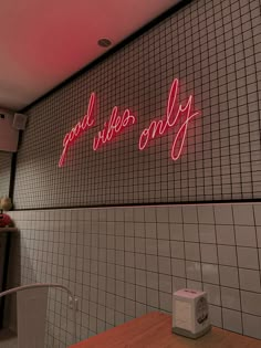 the neon sign above the counter says, good vibes only on it's wall