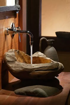 a wooden bowl sink sitting on top of a counter next to a faucet