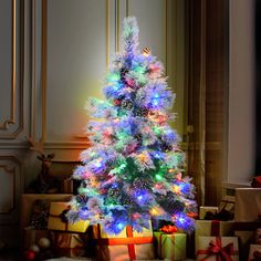 a brightly lit christmas tree surrounded by presents