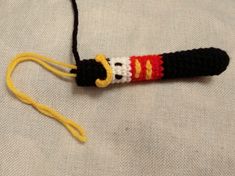 a crocheted key chain with a red, white and yellow handle