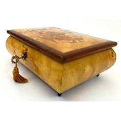 an old wooden box with a tasseled handle