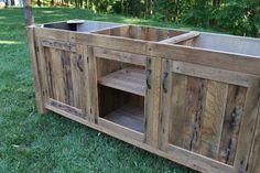 a wooden cabinet sitting on top of a lush green field