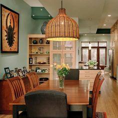 a dining room table with chairs and pictures on the wall