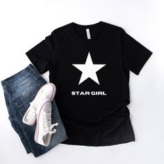 This Star Girl Tee is simple yet effortlessly cool, which makes the perfect trendy summer shirt for anyone. The material feels soft and lightweight, with its relaxed fit that is suitable for all.  About:  * 100% combed and ring-spun cotton (Heather colors contain polyester) * Fabric weight: 4.2 oz/yd² (142 g/m²) * Pre-shrunk fabric * Side-seamed construction * Shoulder-to-shoulder taping Thank you for visiting HonecloverdesignsCo! We provide all kinds of Designs and print them on shirts for you Casual Black T-shirt With Star Print, Trendy Summer T-shirt With Star Patch, Summer Cotton T-shirt With Star Patch, Casual Black Top With Star Patch, Trendy Relaxed Fit T-shirt With Star Print, Casual Crew Neck T-shirt With Star Patch, Trendy Streetwear Tops With Star Patch, Graphic Tee With Star Logo For Summer, Trendy Black Top With Star Patch