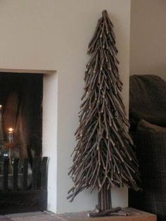 a wooden christmas tree next to a fireplace