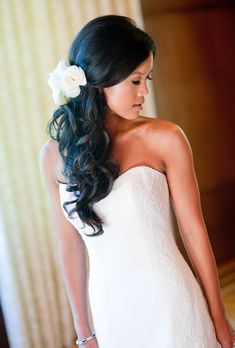 a woman in a wedding dress with flowers in her hair