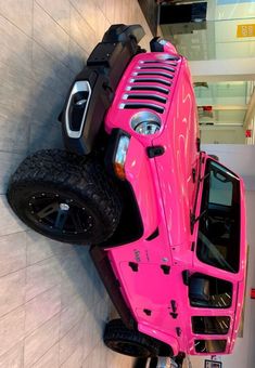 a pink four wheeler parked next to a white wall