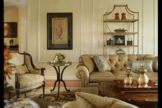 a living room with two couches and a coffee table in front of a painting on the wall