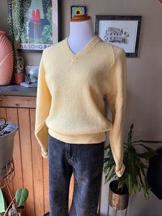 This knit pullover sweater is made from pure wool in a beautiful soft buttery yellow with a v-neckline and folded cuffs.  Label: Shelby Wool Paca Size: Medium Measurements (taken flat): Pit to pit - 19.5" Hem - 17" Shoulder to hem - 23.5" Pit to hem - 12.5" Great vintage condition - there is just one very small brown spot in the right sleeve as pictured Feel free to message me for more measurements, pictures, or to ask any other questions you might have! Please see my shop policies regarding shi Yellow V-neck Sweater Affordable, Vintage V-neck Knit Sweater, Wool V-neck Knitted Sweater, Spring V-neck Wool Sweater, Spring Wool V-neck Sweater, Vintage Long Sleeve V-neck Sweater For Winter, Wool Knitted V-neck Top, V-neck Wool Knitted Tops, Knitted Wool V-neck Tops