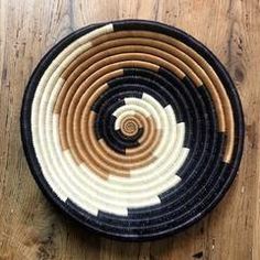 a black and white basket sitting on top of a wooden floor