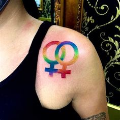 a woman with a tattoo on her arm that has the symbol of two men and women