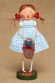 a figurine is holding a basket with a bird in it's mouth