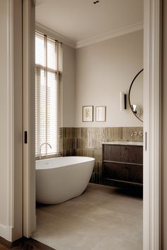 a bathroom with a large white bathtub sitting next to a window