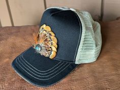 Transform your look with our Golden Trucker Hat. This versatile hat is great for music festivals, outdoor activities, and more. Channel your inner rocker and country music aficionado while staying comfortable and stylish in western fashion. It features a classic chino twill front panel and a soft tea stain mesh back panel. The antique silver Southwestern-inspired Concho with faux turquoise adds a touch of rustic charm. With a velcro closure and a comfort sweatband, it's perfect for all head sizes. Country Style Hat Bands For Outdoor, Trucker 5-panel Hats For Rodeo, Trucker 5-panel Rodeo Hat, Adjustable 5-panel Hat For Rodeo, Adjustable 5-panel Rodeo Hat, Western Style 5-panel Trucker Hat For Rodeo, Casual Outdoor Hat Bands For Fall, Western Style Snapback Trucker Hat For Outdoor, Western Style Adjustable Trucker Hat 5-panel