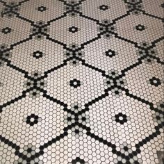 a black and white tiled floor with hexagon mosaic tile pattern on the bottom