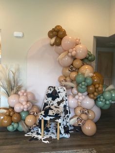 a chair sitting in front of a bunch of balloons