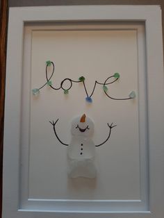 a snowman made out of glass with the word love written on it