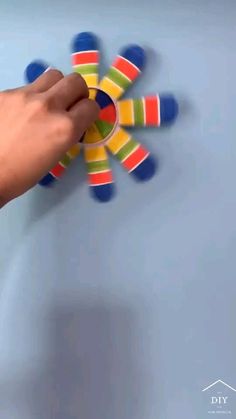 a hand is holding an object that appears to be spinning on the surface with colorful circles