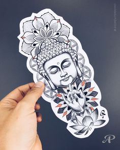 a person holding up a sticker with a buddha face on it's side