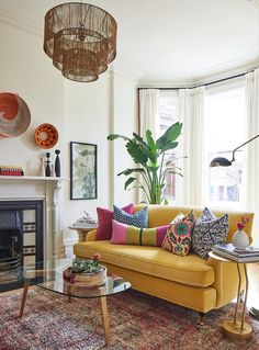 a living room filled with furniture and a fire place in front of a large window