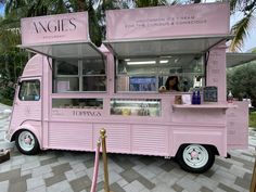 a pink food truck parked on the side of a road