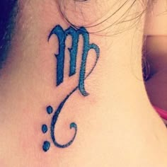 a woman's upper back neck tattoo with the letter m on it