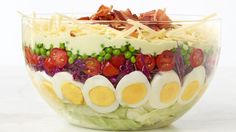 a salad with hard boiled eggs, tomatoes, lettuce and other toppings