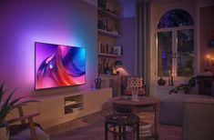 a living room filled with furniture and a large flat screen tv mounted on the wall