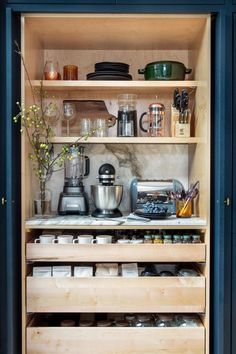 an open cabinet filled with lots of kitchen items