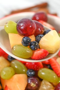 a spoon full of fruit is being held up