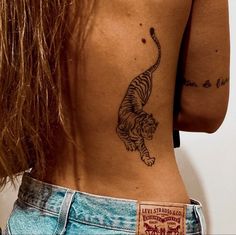 a woman with a tiger tattoo on her lower back and upper back side view,