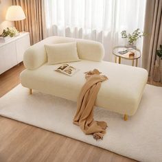 a white bed sitting on top of a hard wood floor next to a window covered in curtains