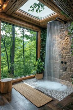 a bathroom with a large window and a waterfall in the shower area, surrounded by greenery