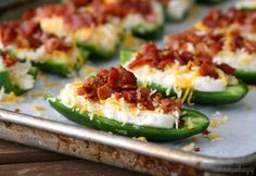 green peppers topped with bacon and cheese on a baking sheet