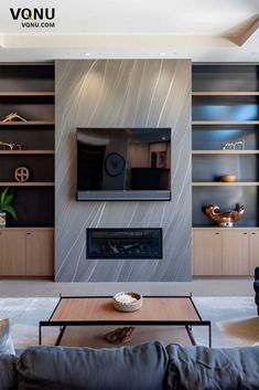 a modern living room with built - in shelving units and a flat screen tv mounted on the wall