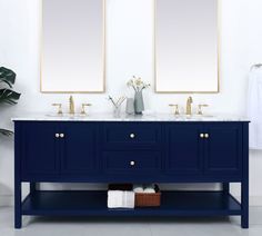 two mirrors are above the double sink vanity in this white and blue bathroom with gold accents