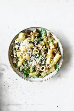 a white bowl filled with pasta and vegetables