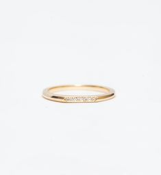 With two faces, this ultra-sleek gold band offers you a beautiful duality. Designed by Bliss Lau to complement her Minimalist Rings, this slender ring features a carefully shaped notch to fit neatly against the solitaire setting. But turn it around and its flat side reveals a glittering pavé of white diamonds, perfect for a sparkling accent to your engagement ring or for subtle brightness on its own. Made in the U.S.A. All sizes available by special order in 4-6 weeks. To inquire, including requ Solitaire Setting, Two Faces, Minimalist Rings, Gold Band, White Diamonds, Gold Bands, Diamond White, Wedding Bands, Gold Rings