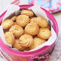 a pink container filled with cookies on top of a table